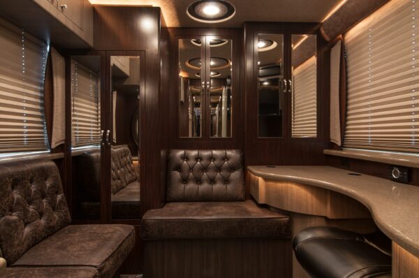 Luxury interior of a vehicle with brown leather seats and polished wood paneling.