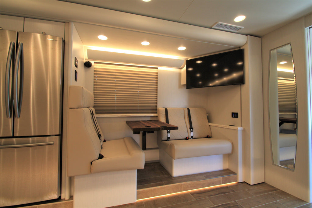 Modern kitchen and living area interior with a refrigerator, dining table, and seating.