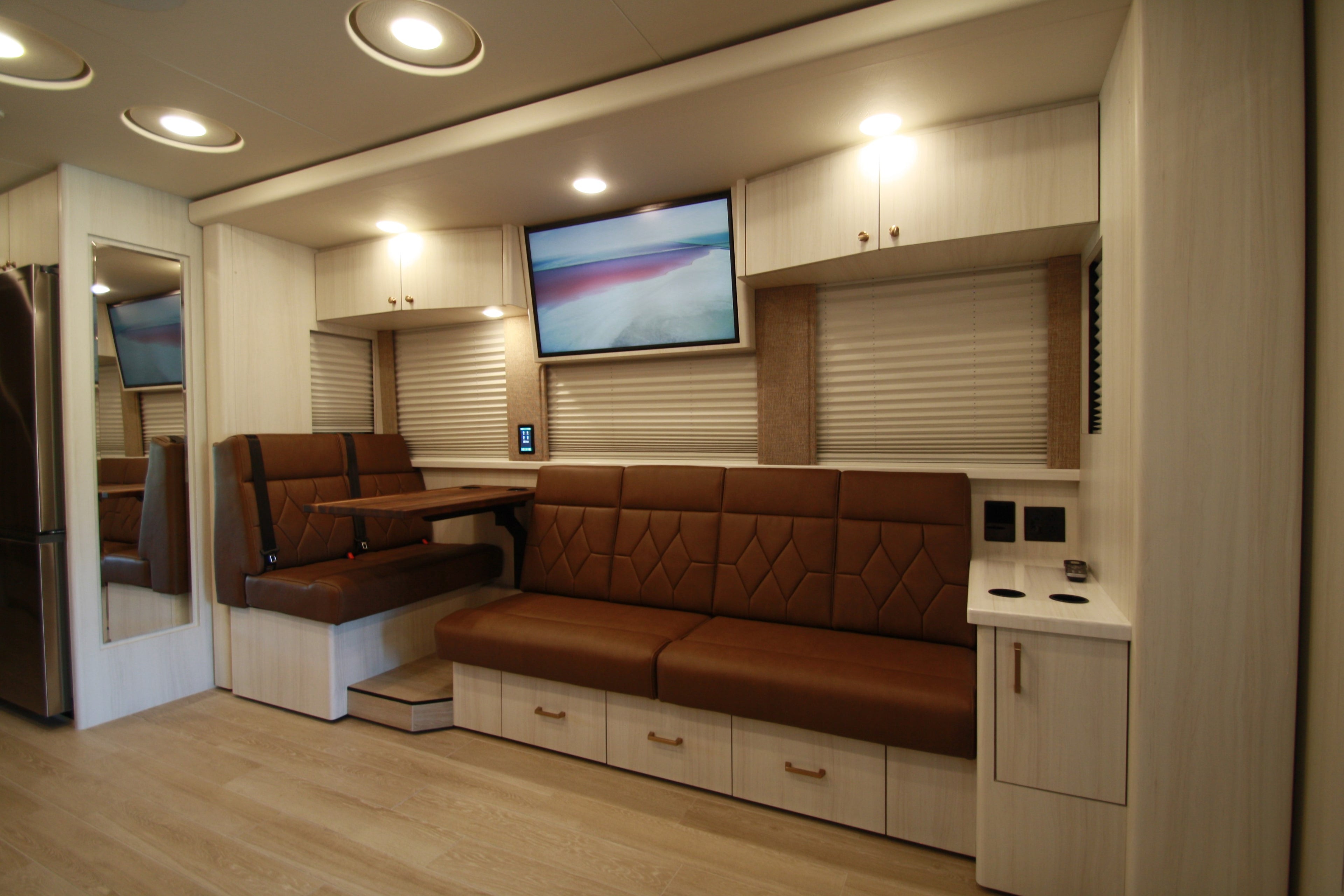Interior of a modern vehicle with brown leather seating and a mounted screen.