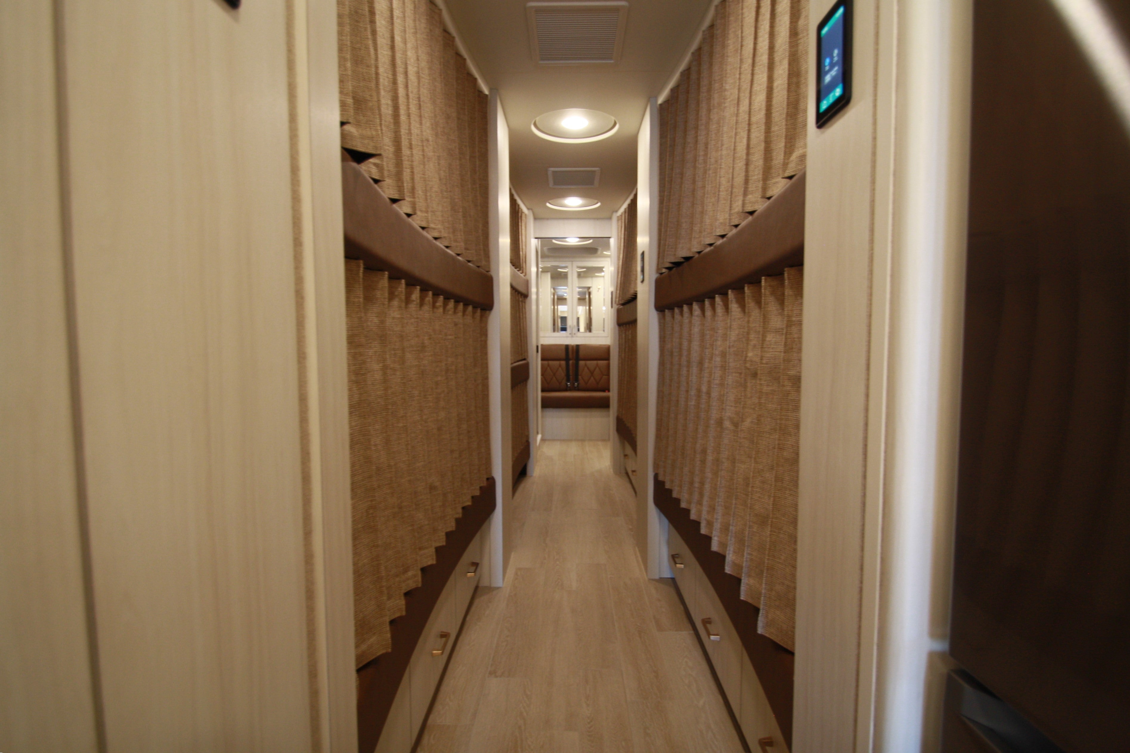 Corridor with bunk beds on either side in a compact living space.